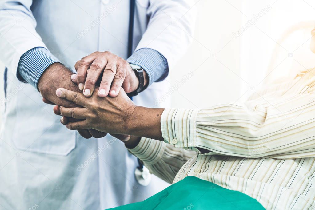 Mature doctor and senior patient in hospital ward.