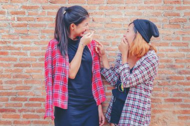 Mutlulukla gülen iki mutlu kadın arkadaş.