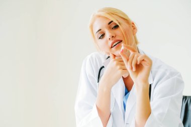 Elinde ilaç hapı tutan genç kadın doktor
