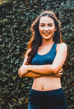 Genç spor kadını parkta sabah egzersizi yapıyor.