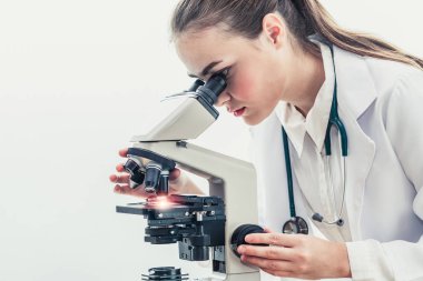 Hastane laboratuvarında mikroskop kullanan doktor.