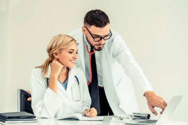 Hastanedeki doktor ortağıyla bilgisayar başında çalışıyor.