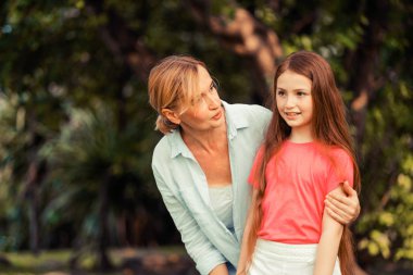 Rahat mutlu anne ve küçük çocuk kız açık havada genel Park. Ebeveyn ve çocuk kavramı.