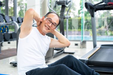 Kıdemli adam fitness merkezinde vücut germe yapmak.