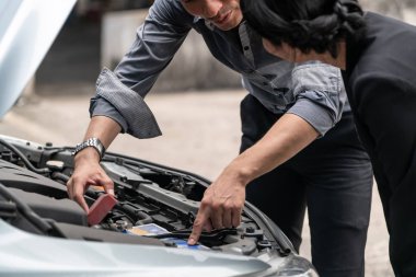 Erkek kadına yardım eder araba sorununu çözer.