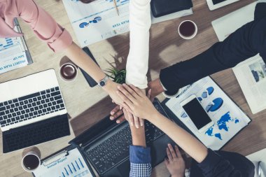 Takım çalışması çalışanları toplantıda el ele tutuşuyor.