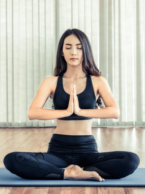 Genç kadın bir spor salonunda yoga pratik.