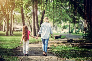 Rahat mutlu anne ve küçük çocuk kız açık havada genel Park. Ebeveyn ve çocuk kavramı.