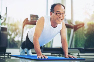 Yaşlı adam fitness salonunda yukarı itmek.