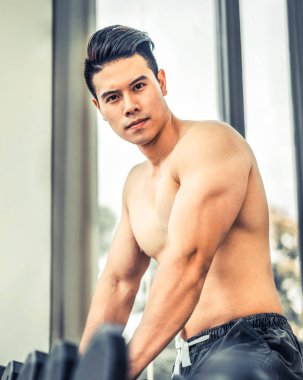 Kaslı adam vücut geliştirmeci dumbbells ile eğitim.