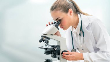 Bilim adamı araştırmacı laboratuvarda mikroskop kullanır