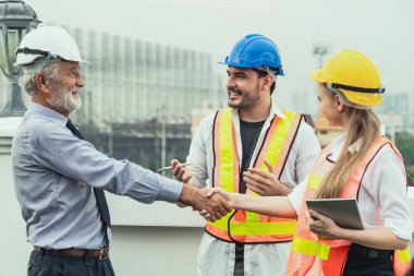 Mühendis, mimar ve iş adamı çalışıyor.