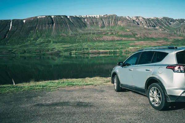 SUV estacionamento de carro no lado do lago com montanha . — Fotografia de Stock