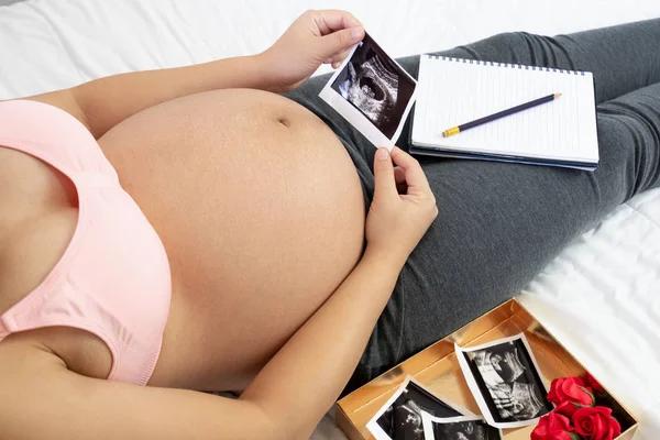 Mujer embarazada feliz y esperando un bebé en casa. — Foto de Stock