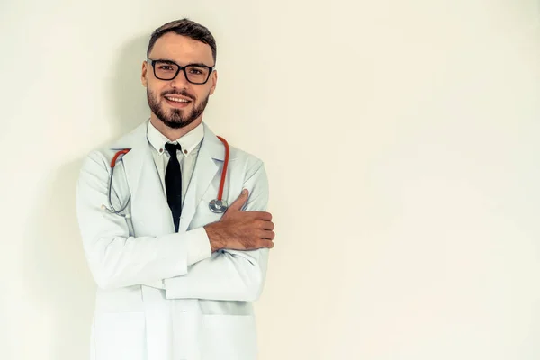 Joven médico con brazos cruzados sobre fondo blanco . — Foto de Stock