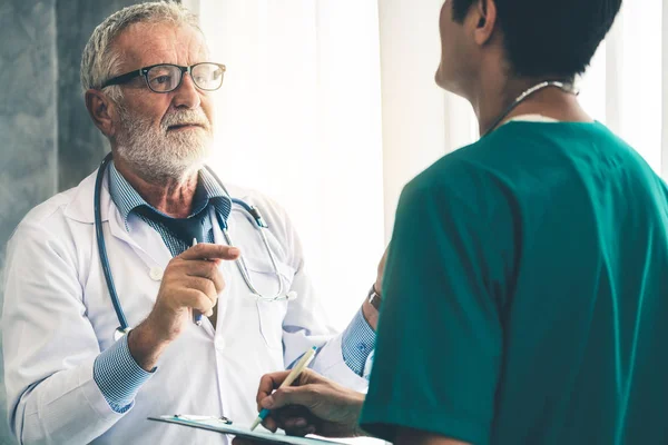 Senior medico di sesso maschile che lavora con un altro medico . — Foto Stock