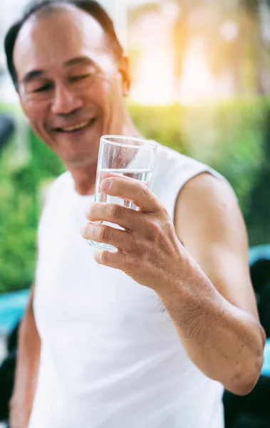 Senior man drink mineral water in fitness center. — Stock Photo, Image