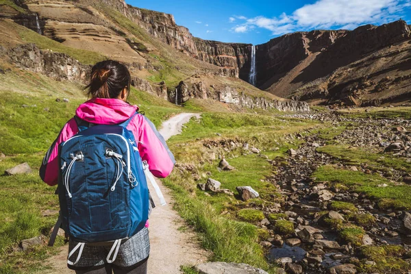 Caminhadas de viajantes em Hengifoss Waterfall, Islândia . — Fotografia de Stock