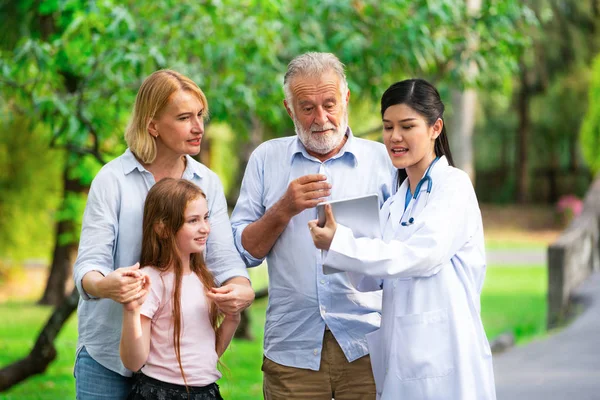 공원에서 말하는 행복한 건강한 가족과 의사. — 스톡 사진