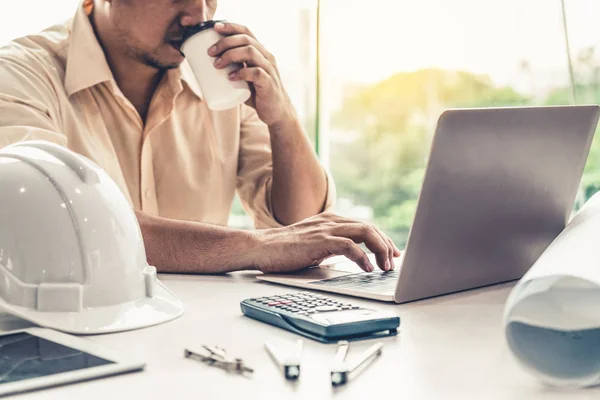 Ung man arkitekt eller ingenjör som arbetar vid skrivbordet. — Stockfoto