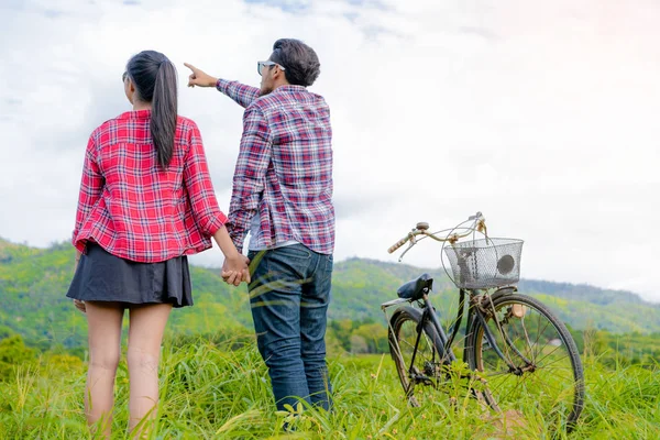 Feliz joven pareja montar en bicicleta en las colinas . —  Fotos de Stock