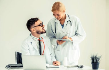 Hastanedeki doktor ortağıyla bilgisayar başında çalışıyor.