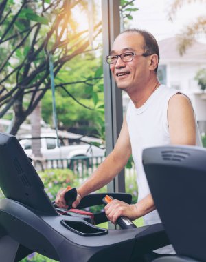 Fitness merkezinde koşu bandı üzerinde Kıdemli adam egzersiz