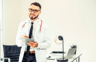 Hastanede tablet bilgisayar üzerinde çalışan doktor.