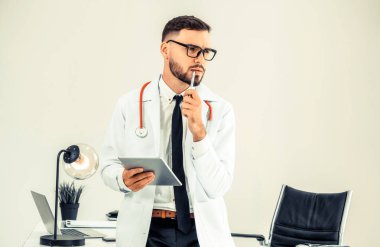 Hastanede tablet bilgisayar üzerinde çalışan doktor.