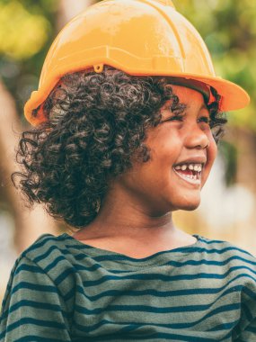 Kask sert şapka giyen mutlu küçük çocuk mühendis.