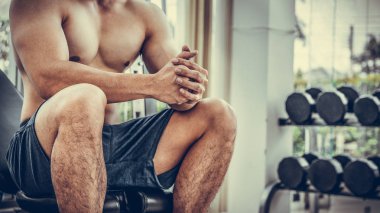 Kaslı adam vücut geliştirmeci dumbbells ile eğitim.