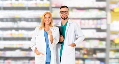 Pharmacist working with colleague in pharmacy. clipart