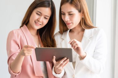 Ofiste tablet bilgisayar kullanan iş kadınları.