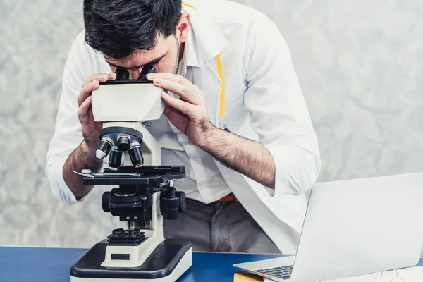 Médico usando microscopio en laboratorio hospitalario . —  Fotos de Stock