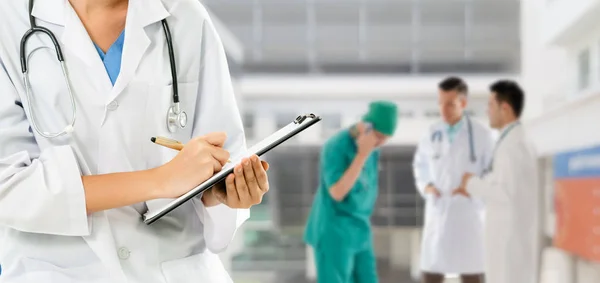 Médico que trabalha no hospital com outros médicos . — Fotografia de Stock