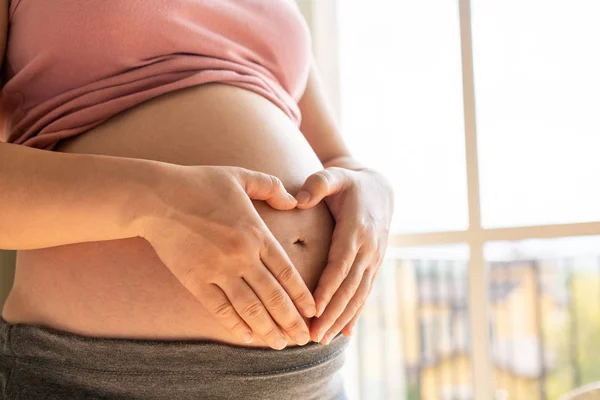 Mujer embarazada feliz y esperando un bebé en casa. — Foto de Stock