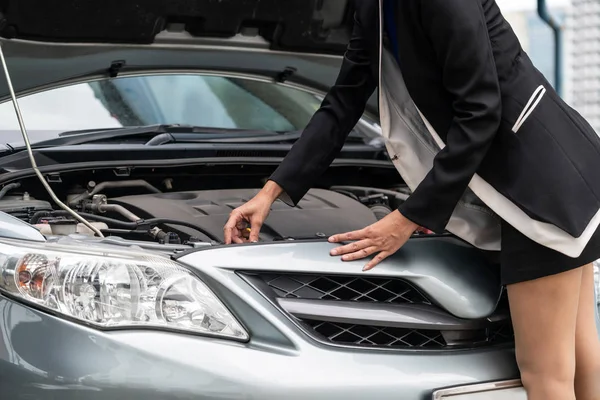 Une femme d'affaires essaie de réparer la voiture toute seule. — Photo