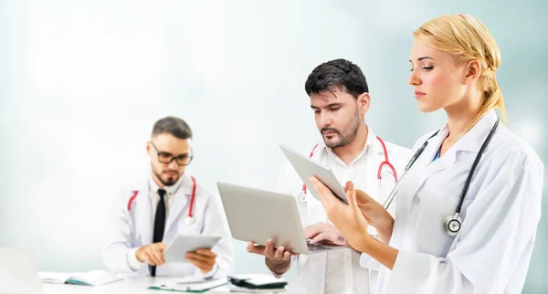 Dokter werkzaam in het ziekenhuis met andere artsen. — Stockfoto