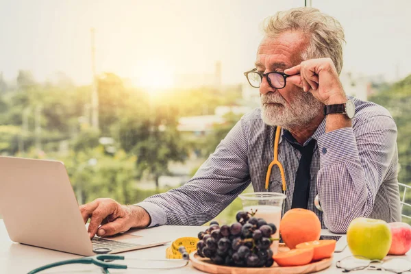 Senior médico nutricionista masculino que trabaja en el ordenador portátil . —  Fotos de Stock