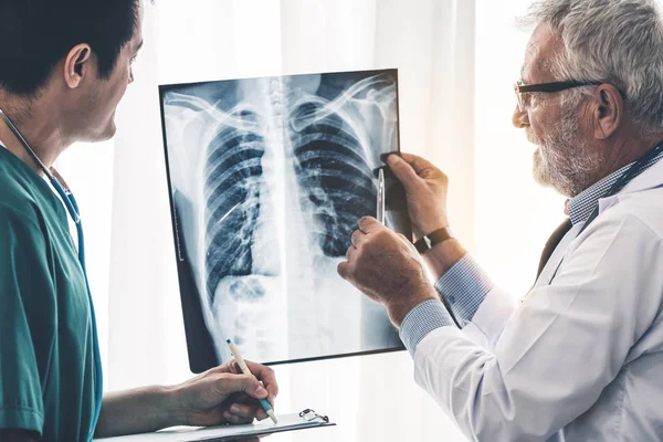 Médicos que trabajan con radiografías del tórax del paciente . — Foto de Stock