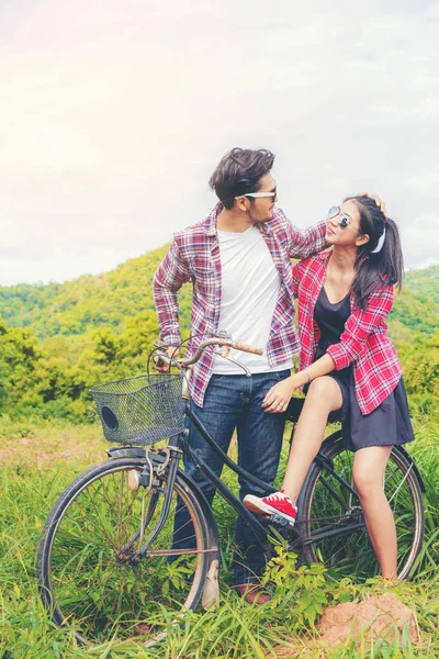 Joyeux jeune couple faire du vélo sur les collines . — Photo