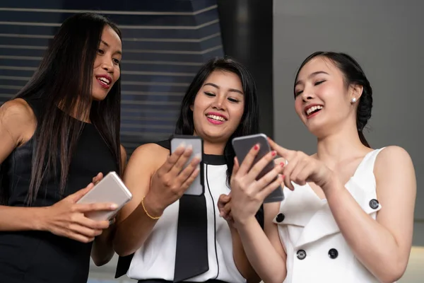 Tres mujeres amigos chatear con el dispositivo de teléfono móvil. —  Fotos de Stock