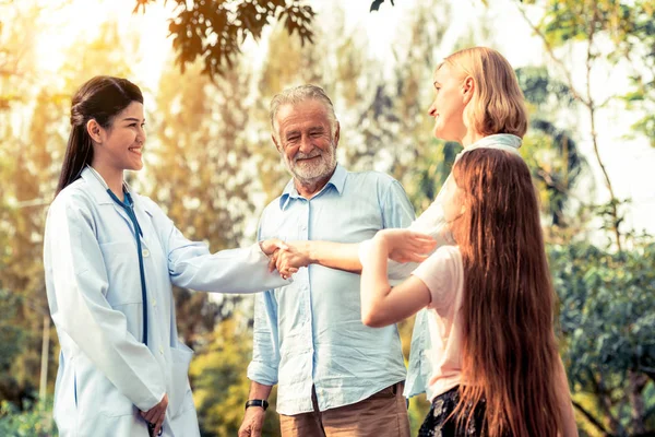 Feliz familia sana y médico hablando en el parque . —  Fotos de Stock