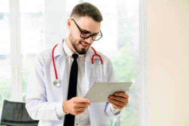 Hastanede tablet bilgisayar üzerinde çalışan doktor.