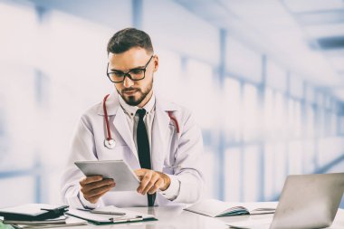 Hastanede tablet bilgisayar kullanan bir doktor..