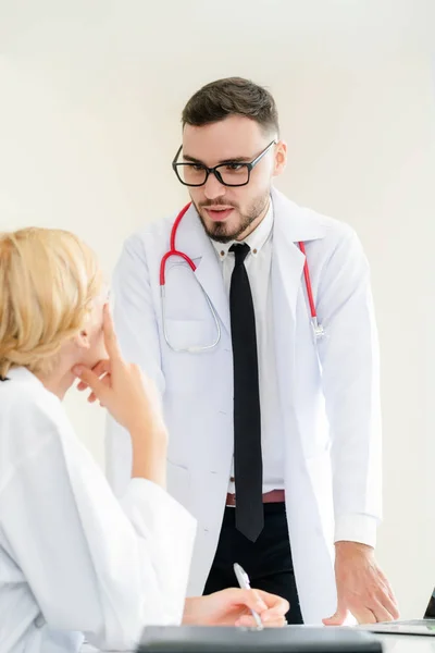 Kvinnlig läkare på sjukhuset pratar med sin partner. — Stockfoto