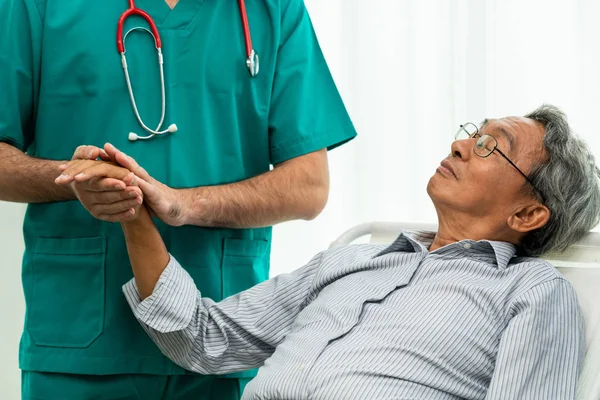 Mannelijke arts Holding hand van senior volwassen patiënt. — Stockfoto