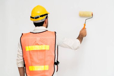 Duvarı boyayan inşaat işçisi.