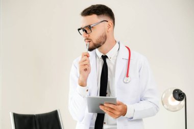 Hastanede tablet bilgisayar üzerinde çalışan doktor.