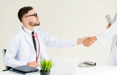 Hastanedeki doktor başka bir doktorla el sıkışıyor